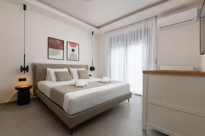 a white bedroom with a bed and a window at Mirena Luxury Living-Casa di Maria in Afantou