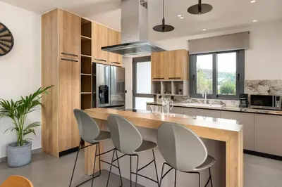 a kitchen with a large wooden island with gray stools at Mirena Luxury Living-Casa di Maria in Afantou