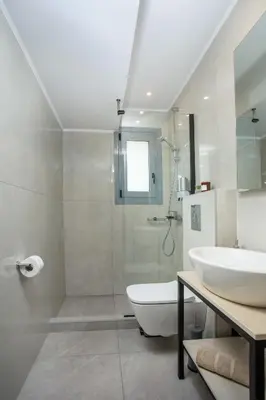 a white bathroom with a sink and a shower at Aetheria Central Apartments in Rhodes Town