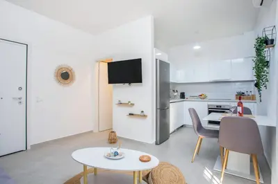 a living room with a table and a kitchen at Aetheria Central Apartments in Rhodes Town