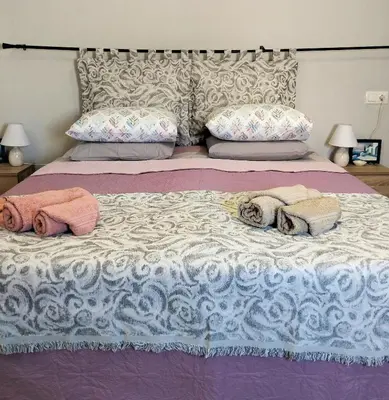 a bed with two towels and pillows on it at The Mill House Stella in Symi