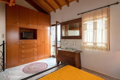 a bedroom with a bed and a dresser and a television at Villa Lola in Halki