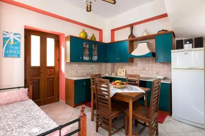 a kitchen with blue cabinets and a table and chairs at Villa Lola in Halki
