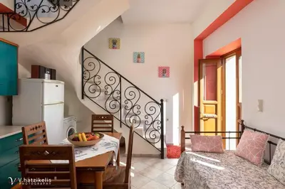 a kitchen and dining room with a table and a room with a staircase at Villa Lola in Halki