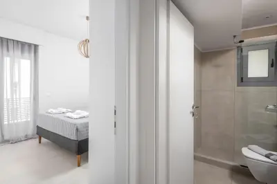 a white bathroom with a bed and a shower at Rhodes Retreat & Getaway Apartments in Rhodes Town