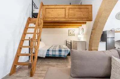 a loft bed with a ladder in a room at Amalia's Traditional Home in Paradisi in Paradeísion
