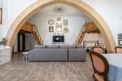 a living room with a couch and an archway at Amalia's Traditional Home in Paradisi in Paradeísion