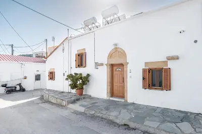 a white building with a wooden door and windows at Amalia's Traditional Home in Paradisi in Paradeísion