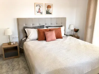 a bedroom with a large bed with orange and white pillows at Luxury Villa Anemone with private pool in Pastida