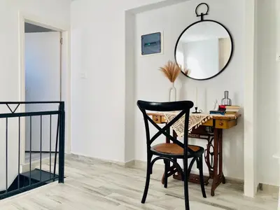 a desk with a chair and a mirror on a wall at Nonna Cannella in Rhodes Town
