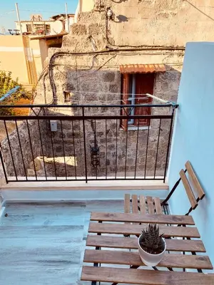 a wooden bench sitting on a balcony with a window at Nonna Cannella in Rhodes Town