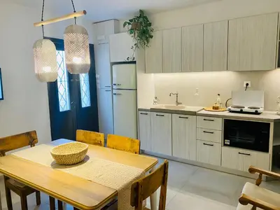 a kitchen with a wooden table and a dining room at Nonna Cannella in Rhodes Town
