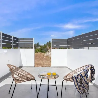 a patio with two chairs and a table at Kimia Luxury Apartments in Kolimbia