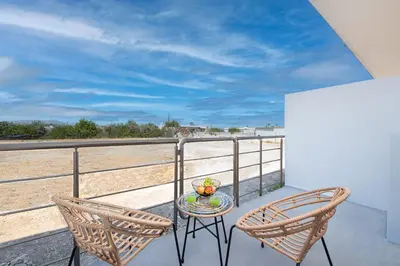 a table and two chairs on a balcony with the beach at Kimia Luxury Apartments in Kolimbia