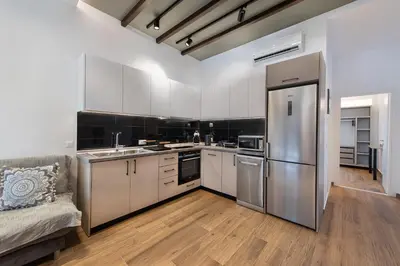 a kitchen with white cabinets and a stainless steel refrigerator at Kimia Luxury Apartments in Kolimbia