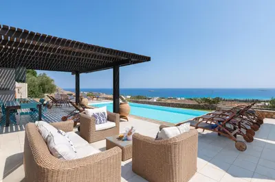 a patio with wicker chairs and a swimming pool at Villa Athena with Private Pool and Seaview in Líndos