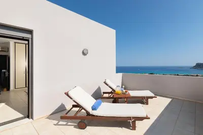 a patio with two lounge chairs and a table at Villa Athena with Private Pool and Seaview in Líndos