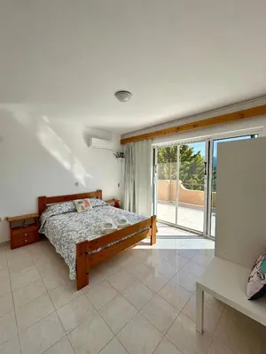 a bedroom with a bed and a sliding glass door at Green View Appartment (Thanasis 2) in Kalavárda