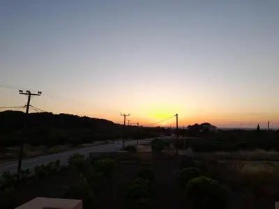 a sunset over a road with the sun setting at Green View Appartment (Thanasis 2) in Kalavárda