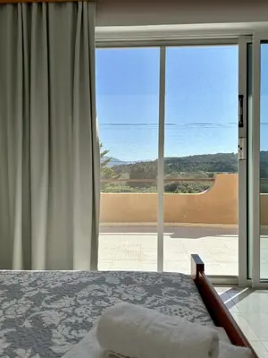 a bedroom with a bed and a large window at Green View Appartment (Thanasis 2) in Kalavárda