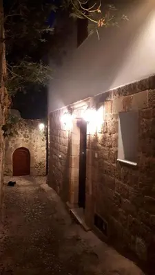a stone wall with lights on it at night at Marietta's House in Rhodes Town