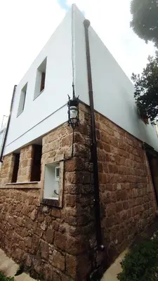 a light on the side of a brick building at Marietta's House in Rhodes Town