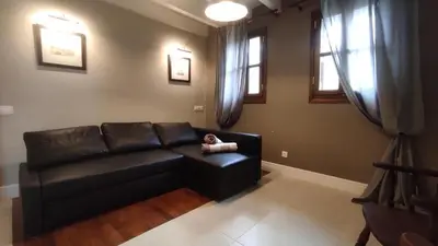 a living room with a black leather couch at Marietta's House in Rhodes Town