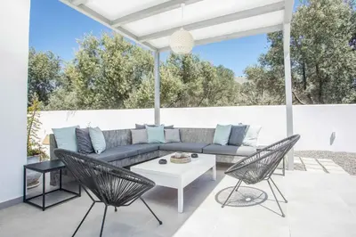 a patio with a couch and two chairs and a table at VillaPhysis with Private Pool in Lardos