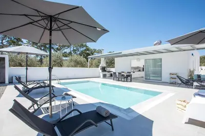 a villa with a swimming pool with umbrellas at VillaPhysis with Private Pool in Lardos