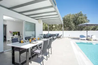 a patio with a table and chairs next to a swimming pool at VillaPhysis with Private Pool in Lardos