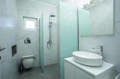 a white bathroom with a sink and a shower at VillaPhysis with Private Pool in Lardos