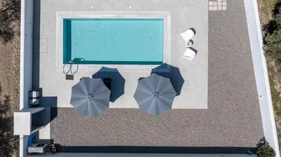 an overhead view of a swimming pool with umbrellas at VillaPhysis with Private Pool in Lardos