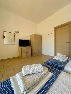 a large room with two beds and a television at Garden View Appartment (Thanasis) in Kalavárda