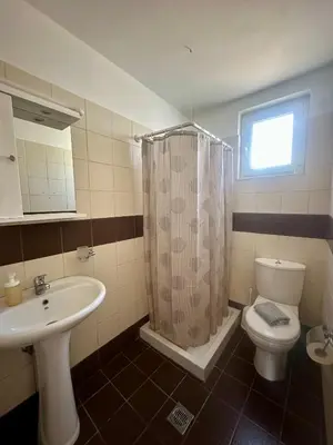 a bathroom with a sink and a toilet and a window at Garden View Appartment (Thanasis) in Kalavárda