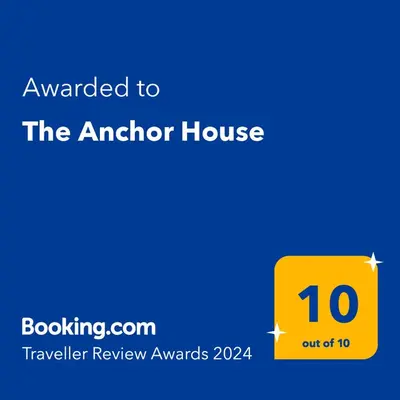 a yellow sign that says awarded to the anchor house at The Anchor House in Symi