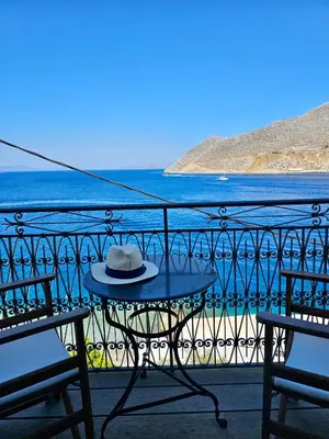 a hat sitting on a table on a balcony at The Anchor House in Symi