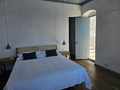 a bedroom with a large white bed with two pillows at The Anchor House in Symi