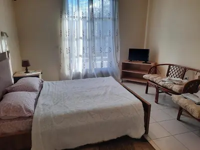 a bedroom with a bed and a chair and a television at Villa Bianca in Kremasti