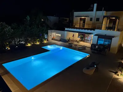 a swimming pool in a backyard at night at Villa Chrysa Rhodes with Heated Pool in Afantou
