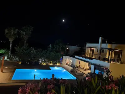 a view of a swimming pool at night at Villa Chrysa Rhodes with Heated Pool in Afantou