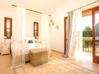 a bedroom with a bed and a bathroom with a window at Holiday Home near Beach in Afandou in Koskinou