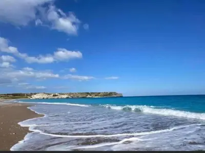 a beach with waves on the sand and the ocean at Holiday Home near Beach in Afandou in Koskinou