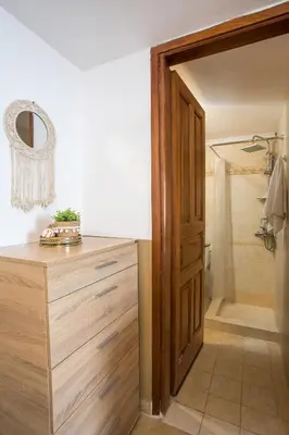 a bathroom with a wooden dresser and a shower at Annas Houses in Halki