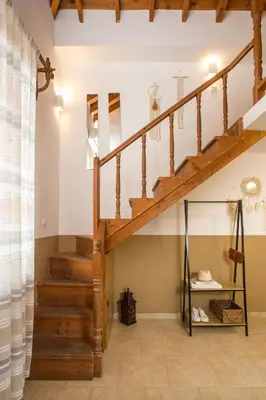a staircase in a living room with a wooden stair case at Annas Houses in Halki