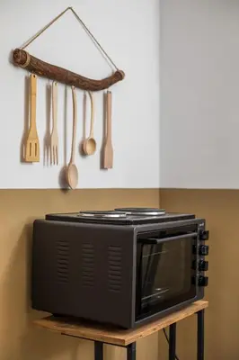 a microwave on a stand in a kitchen with utensils at Annas Houses in Halki