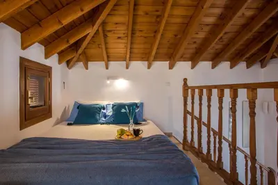 a bedroom with a bed with a blue comforter at Annas Houses in Halki