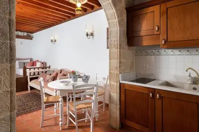 a kitchen and dining room with a table and chairs at Acropolis Lindos House in Líndos