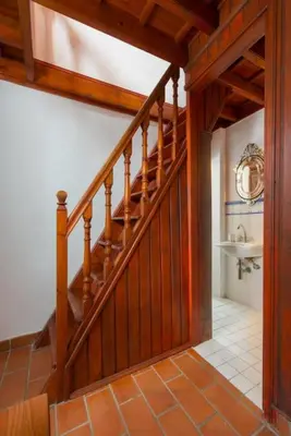 a hallway with a wooden staircase in a house at Acropolis Lindos House in Líndos