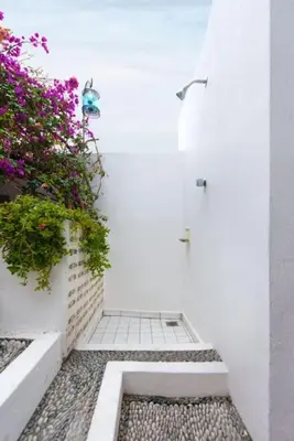 a white hallway with flowers on the side of a building at Acropolis Lindos House in Líndos
