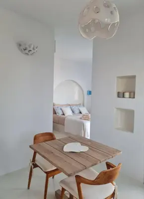 a room with a wooden table and chairs with a bed at Tilos Villa in Livadia